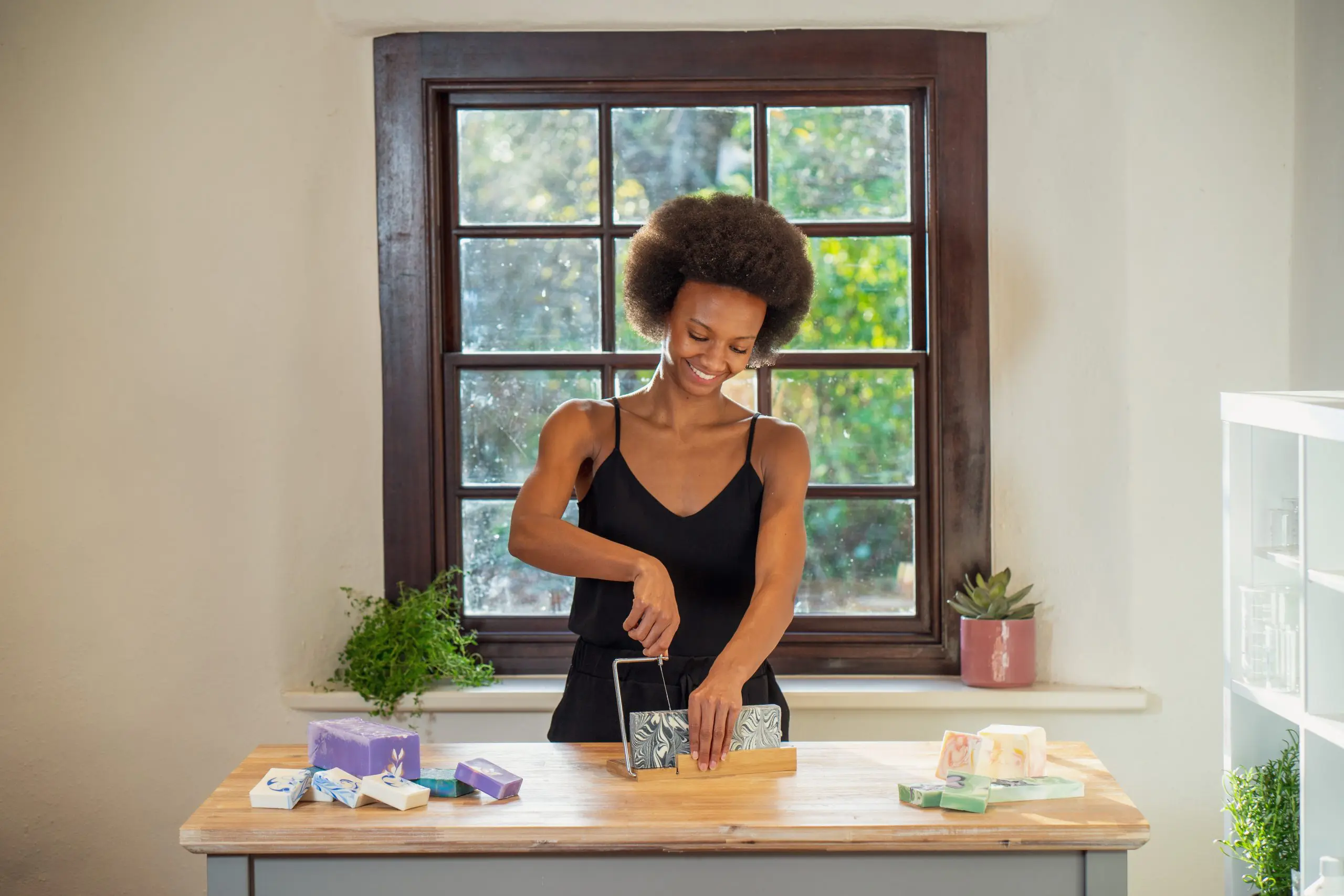 Person cutting handmade soap in bright kitchen