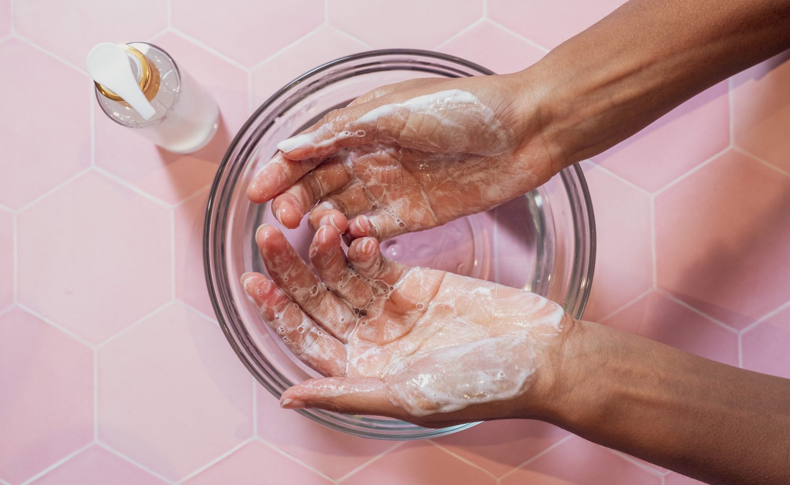 Model-lathering-liquid-soap-1 Hands washing with soap in bowl